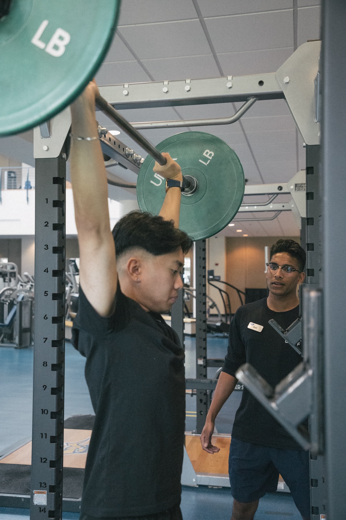 Man power lifting while a trainer stands nearby