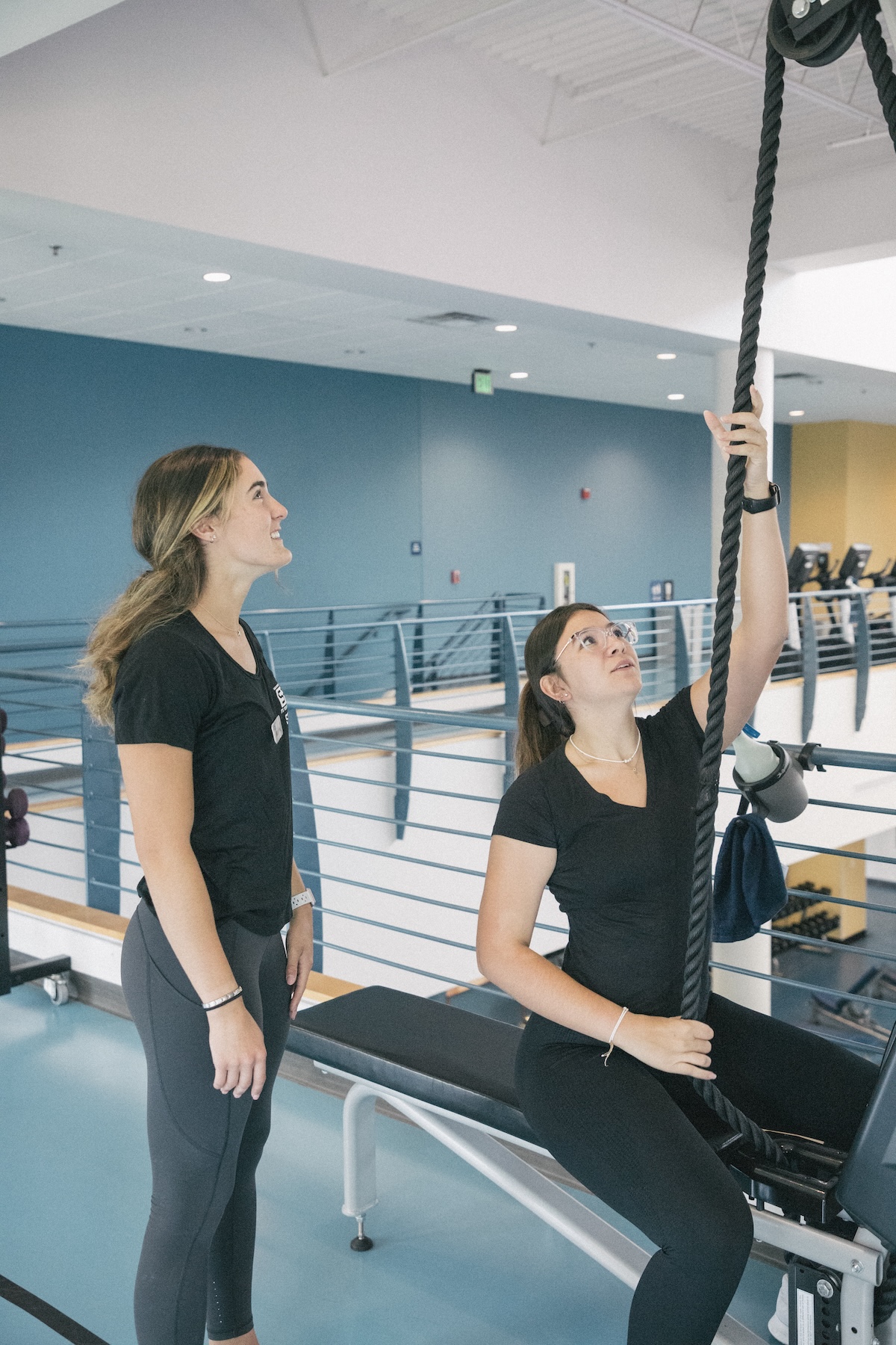 Two women exercising on a rope machine