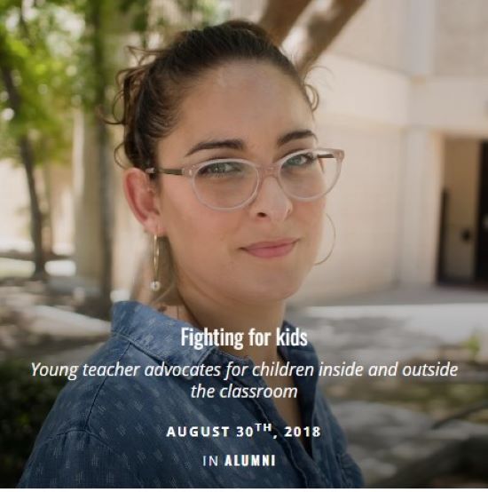 Female with glasses stands in the shadows of trees on the CSUB campus