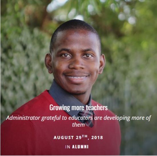 Man in red sweater standing in front of hedges