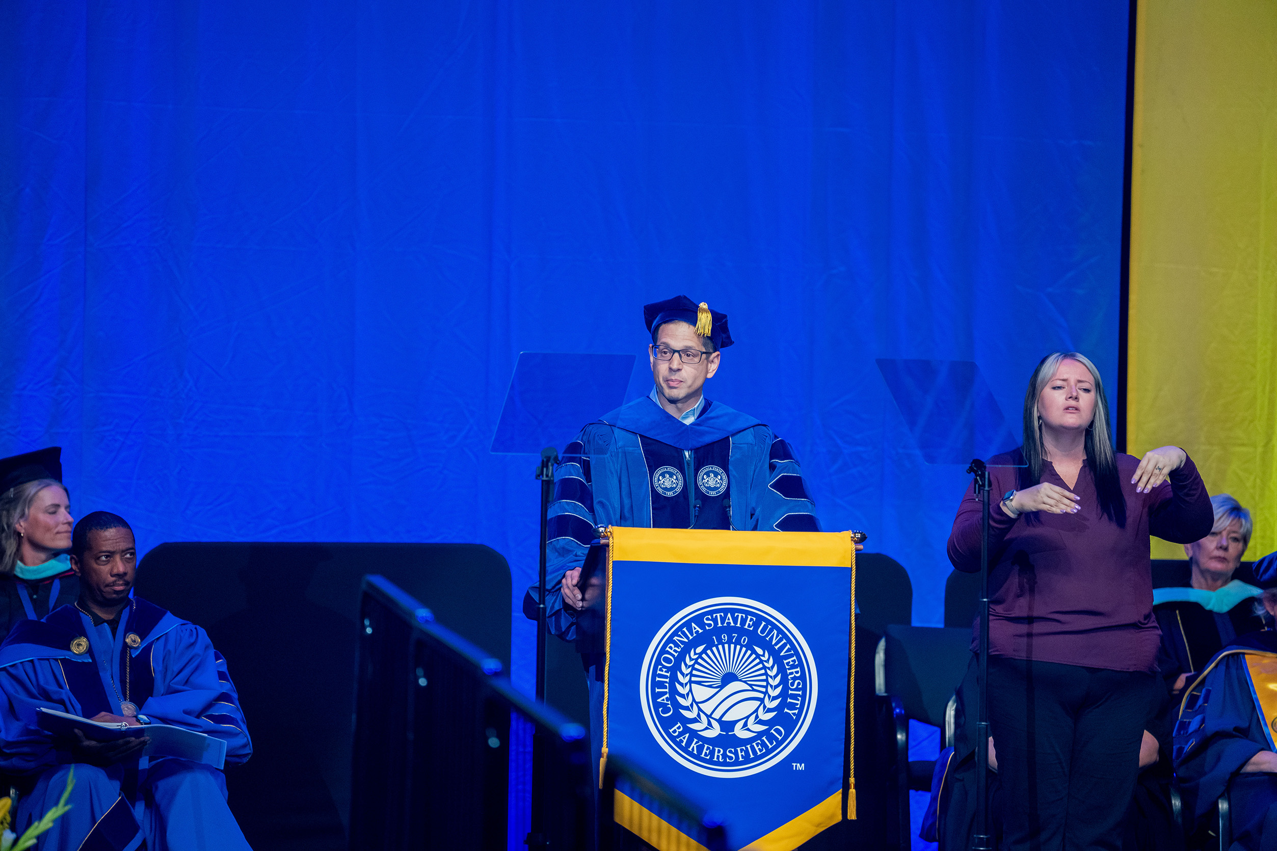 Dr. Herman reads a poem to open commencement