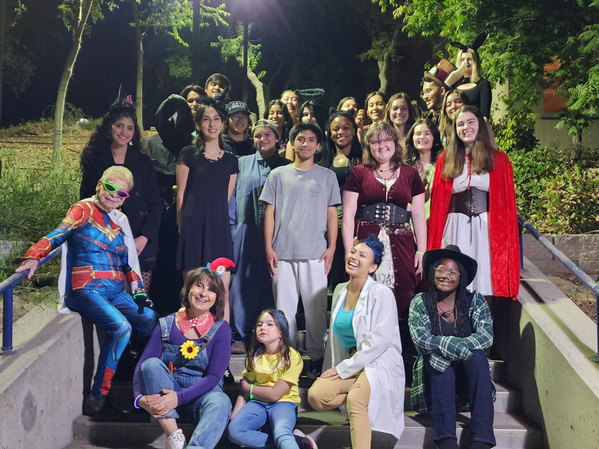 Group of students in Halloween costumes standing on stairway